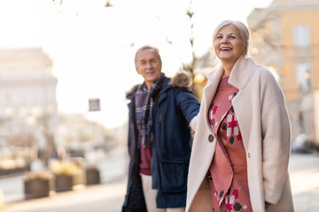 Senior couple walking on the city street at winter day