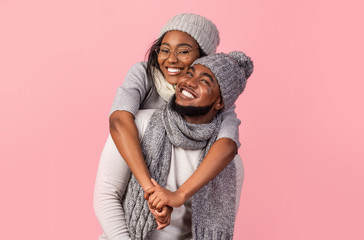 Playful black girl hugging her boyfriend from behind