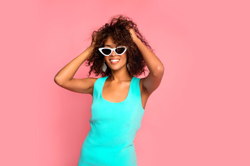Beautiful young african american woman with afro hairstyle posing on pink pastel background wearing...