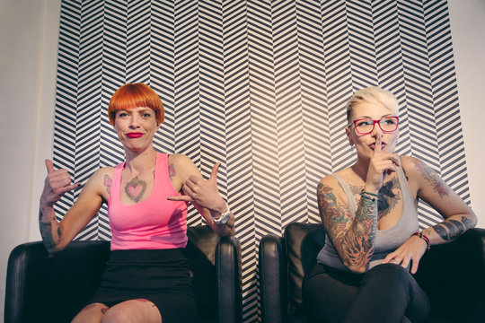 Ragazze tatuate scherzano davanti alla macchina fotografica