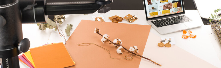 composition with cotton flower and accessories for photo shooting with camera and laptop, panoramic shot