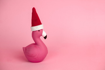pink flamingo in Santa Claus hat on a pink background copy space © dvulikaia