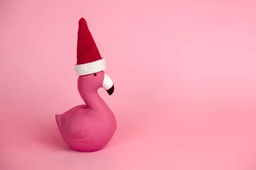 Gardinen pink flamingo in Santa Claus hat on a pink background copy space © dvulikaia
