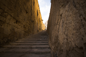 typical narrow street with stairs in the city Valetta