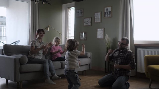 Family Funny Leisure Activity. Happy Parents and Cute Funny Kids Dancing Laughing in Living Room. Mom And Dad With Little Children Having Fun together. Love Lifestyle Home. Slow Motion.