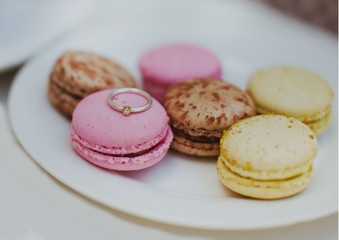 The engagement ring in white gold is depicted on a bright pink cookie. Tasty marriage proposal 