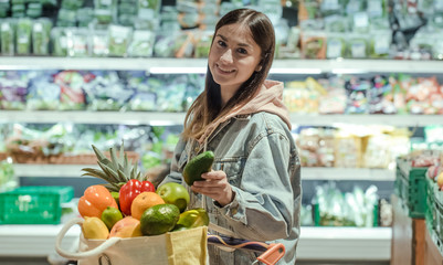 A young woman buys groceries in a supermarket.