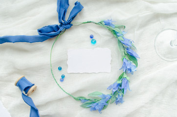 Blue wedding invitation mockup decorated with silk ribbon, crystals and bride wreath