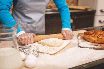 Close-up portrait of attractive smiling happy senior aged woman is cooking on kitchen. Grandmother making tasty baking.