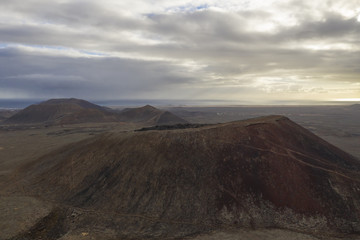 Overcast volcano scene with mountain and coastal backdrop