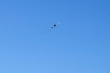 Avión visto desde atrás elevándose en un cielo azul