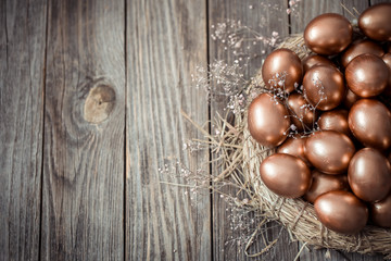 Fototapeta na wymiar Background with Golden Easter eggs on wooden background.