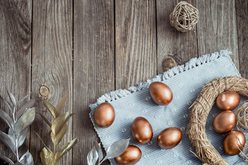 Background with Golden Easter eggs on wooden background.