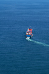 Barco carguero abandonando el puerto y describiendo una curva en su trayectoria