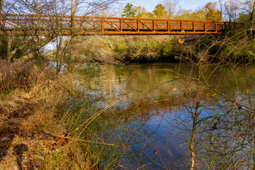 Fototapeta na wymiar a bridge across a slow moving river in autumn.