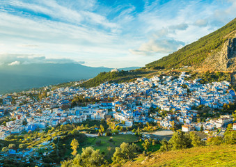 Chefchaouen city in Morocco view with cloudy sky and green hills around