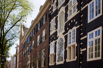 Fototapeta premium View of historical, traditional and typical buildings showing Dutch architectural style in Amsterdam. It is a sunny summer day.