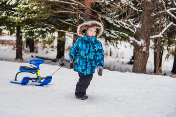 Boy with snow scooter on a walk