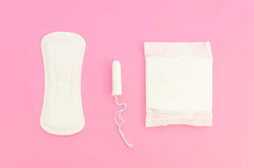 Pink flat lay compostion feminine pads and tampons on a pastel pink background. Menstrual cycle idea