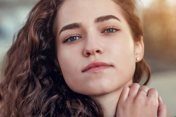 Beautiful brown curly hair. Pretty girl with wavy hair. Portrait of happy woman with beauty face. High quality.