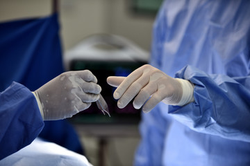 Medical Team Performing Surgical Operation in Modern Operating Room. Equipment and medical devices in hybrid operating room.scrub nurse preparing medical instruments for operation.