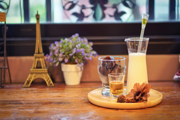 Choosing Focus: An ice heart latte is on a plate, try to put on the table and have a souvenir and a teddy bear near in a warm atmosphere