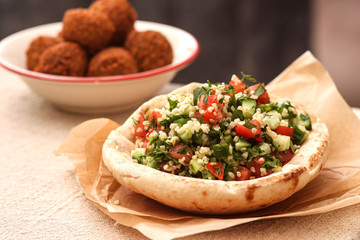 Tabbouleh salad in pita bread with falafel.Traditional middle eastern or arab dish.