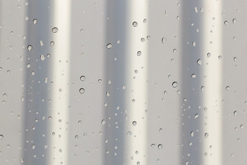 water drops on the glass in winter reflection of the iron wall