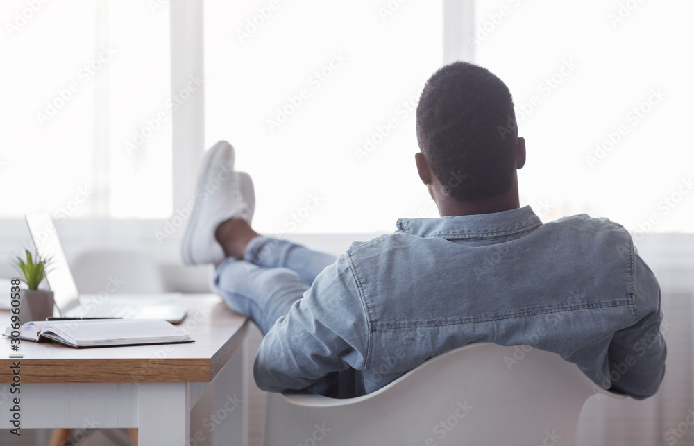 Poster Lazy employee sitting with legs on desk and looking to window