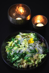 Delicious and colorful green salad with raspberries on dark background in quiet environment