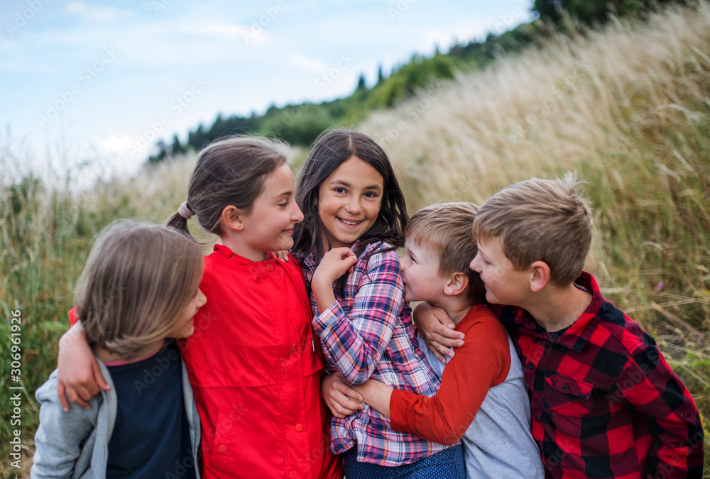 Sticker Group of school children standing on field trip in nature, playing.