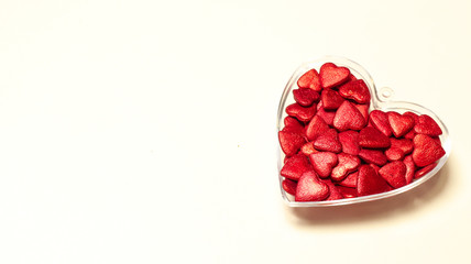Transparent heart-shaped boxe with many small red hearts inside isolated on a white background. Love, wedding and Valentine's Day concept. Copy space