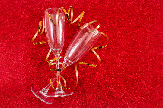 Two Empty Champagne Glasses On Red Shine Background.