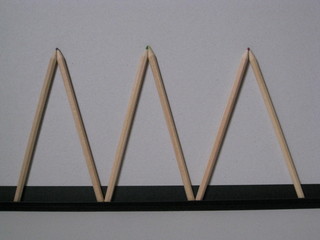 Triángulos hechos con lápices de madera natural con puntas de colores unidas, sobre pequeño...