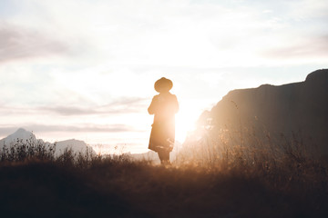 Hipster Girl in a Black Coat Walks in Alpine Mountains
