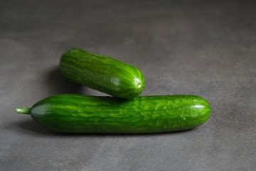 Fresh green cucumbers on a dark background 
