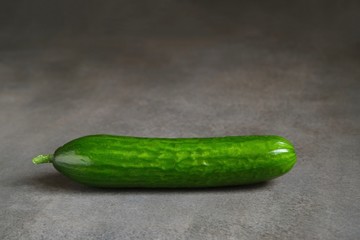 Fresh green cucumbers on a dark background 