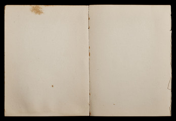 Antique book unfolded showing textured pages isolated on black background.