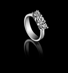 diamond ring with a three stone on a black background