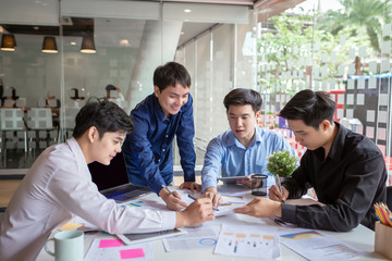 Group of young asian businessman together share opinions and propose new marketing and business ideas at meeting.