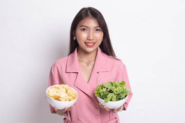 Young Asian woman with potato chips and salad.