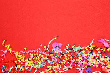 Colorful ribbons with confetti on red background