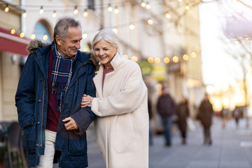 Senior couple walking on the city street at winter day