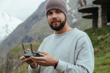 Drone operator pilot with beard in Georgian mountains