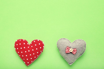 Colorful fabric hearts on green background
