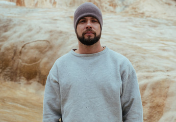 Tourist in Georgian mountains, man with beard in white sweater