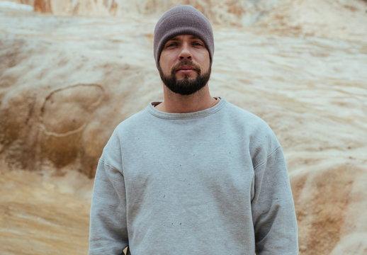 Tourist in Georgian mountains, man with beard in white sweater
