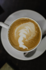 coffee with milk in a white Cup on a black background