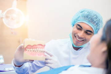 Asian dentist and the patient are preparing to treat carious teeth in the dental clinic