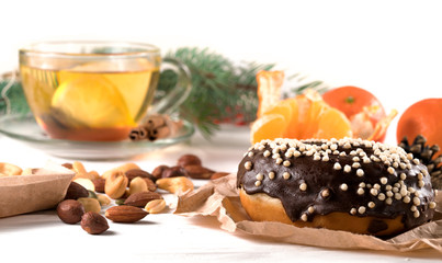 Fototapeta na wymiar .donut, nuts and tangerines and branches of a Christmas tree on a white background